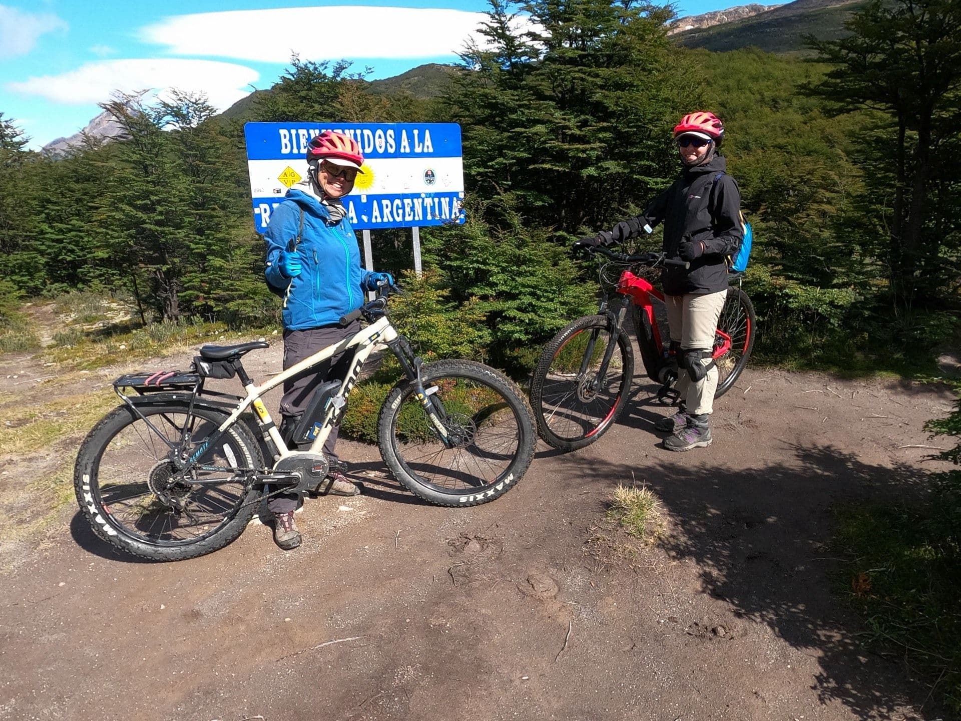 Ciclistas junto al cartel de bienvenida a Argentina, en el hito fronterizo del Paso Dos Lagunas