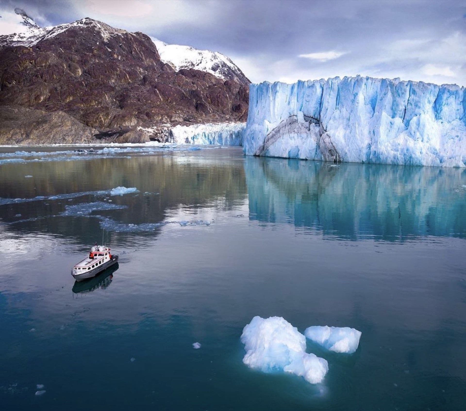 El muro del Gran Glaciar O'Higgins, con una de nuestras naves navegando frente al hielo